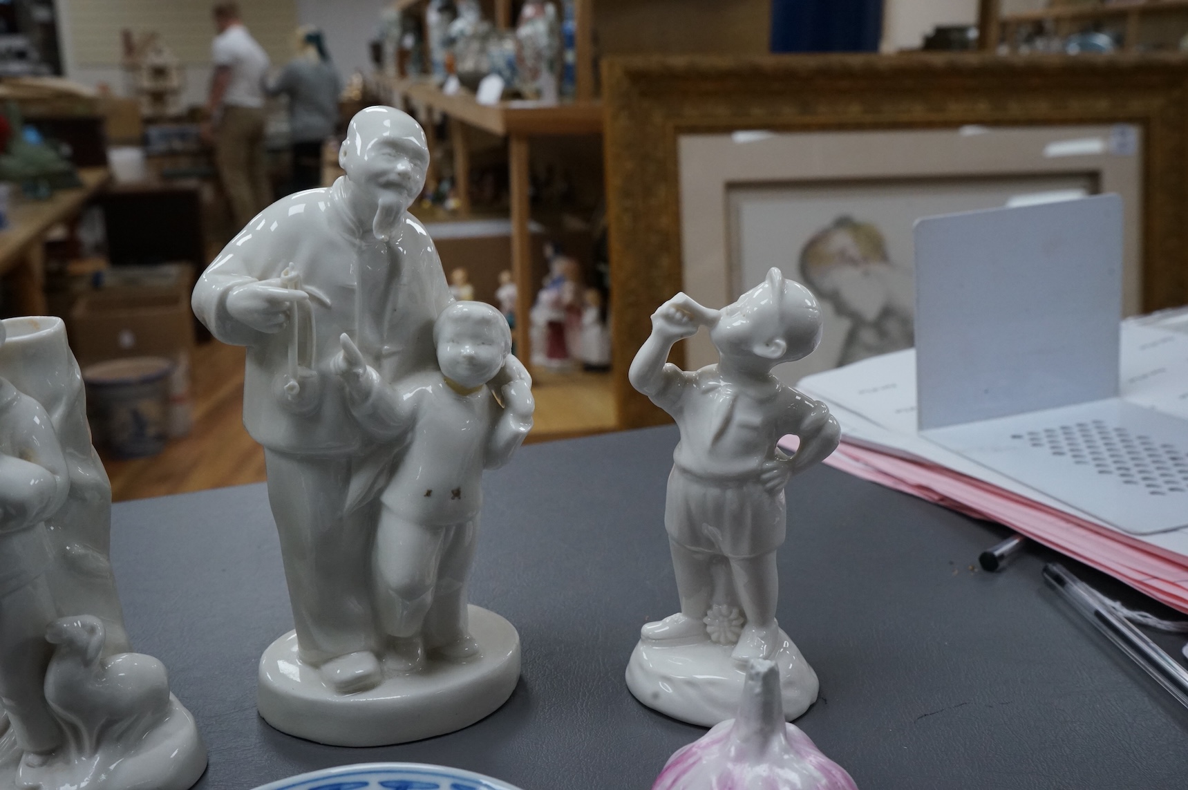 Four Chinese blanc de chine figures and two blue and white dishes and a model of a garlic bulb. Tallest figure 17.5cm.